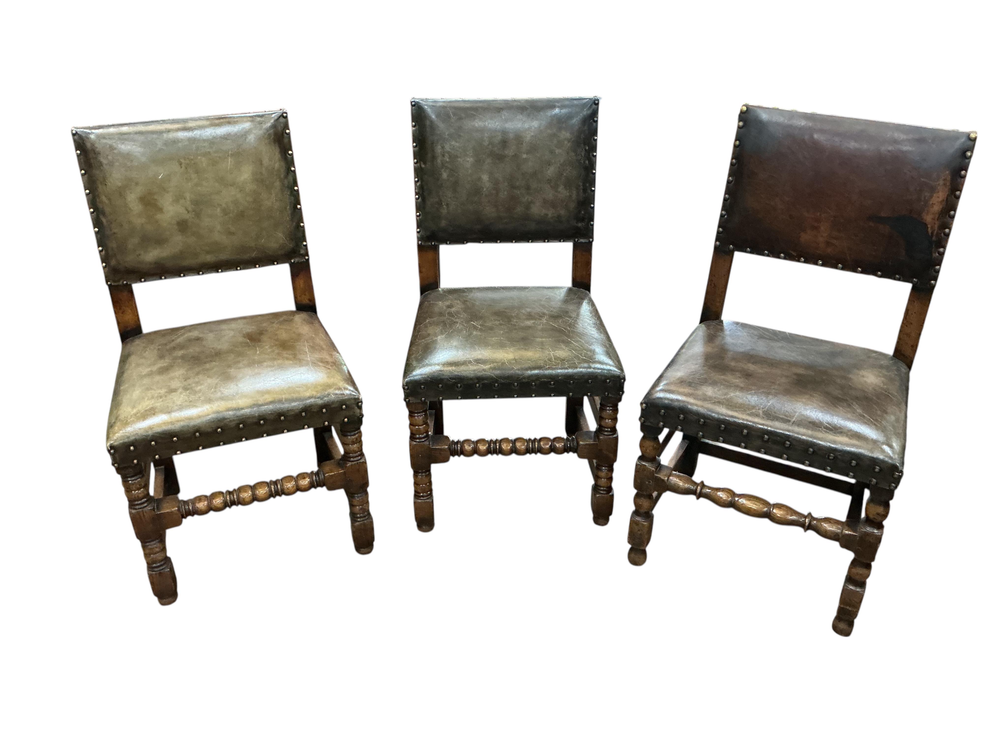 A set of eight Cromwellian style oak and tan leather dining chairs, two with arms